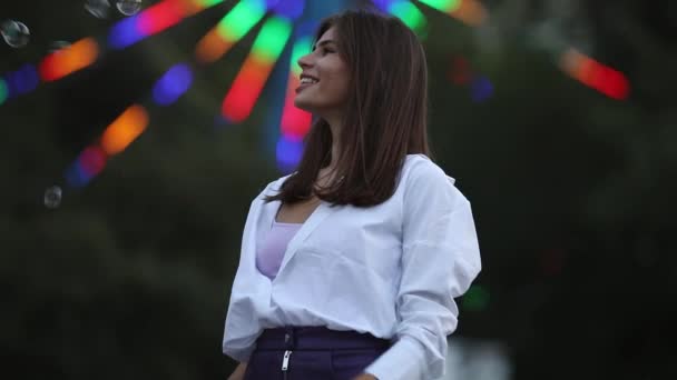 Glada vuxna flicka fångster bubblor i en park pariserhjul bakgrund — Stockvideo