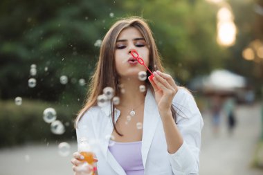 Parkta baloncuk çıkaran mutlu kız.