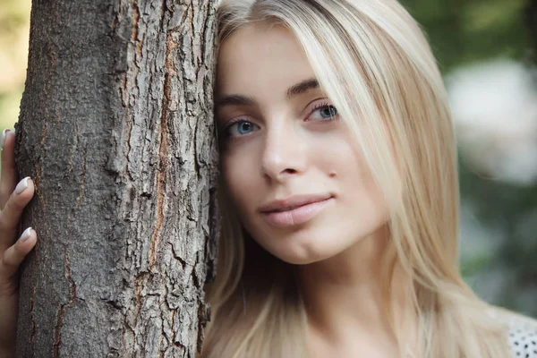 Kadın eğilimli baş ağaç gövdesi için güzel mavi gözlü kız
