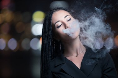 Gece şehirde kadın vaping