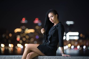 Çit gece şehirde oturan seksi kadın