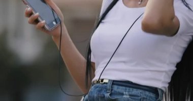 Kadının Şehir Meydanı'nda oturan müzik dinlemek