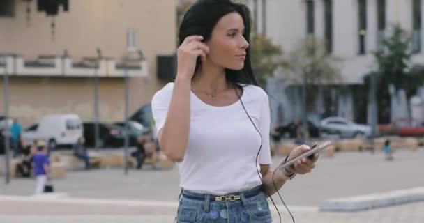 Gioiosa donna che balla ascoltando musica in città con il cellulare — Video Stock