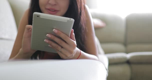 Mujer usando la aplicación de tableta digital PC en el hogar acostado en el sofá — Vídeos de Stock