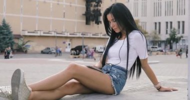 Kulaklık City ile cep telefonu kullanan kadın