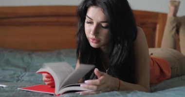 Kadın evde yatakta kitap okumak