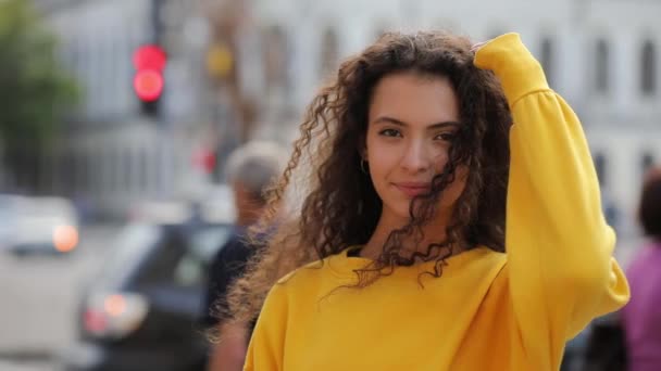 都市の背景、黄色のジャージーでかわいい巻き毛の十代の少女 — ストック動画