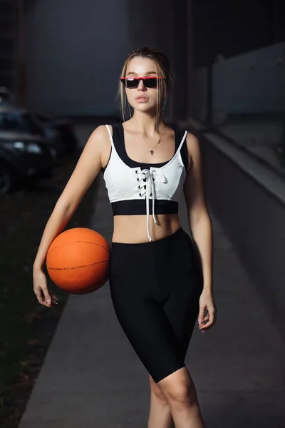 ファッショナブルな陽気な女性がバスケット ボールを保持しているフィットのブラジャーのポーズ — ストック写真