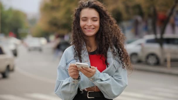 Dívka se směje na cizí žena v městě drží chytrý telefon — Stock video