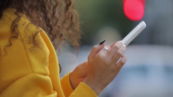 Main féminine tenant à l'aide de l'application sur l'écran tactile du smartphone 
