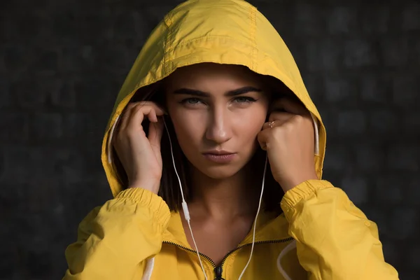 Mujer Seria Bajo Capucha Amarilla Con Auriculares Escuchar Una Música —  Fotos de Stock