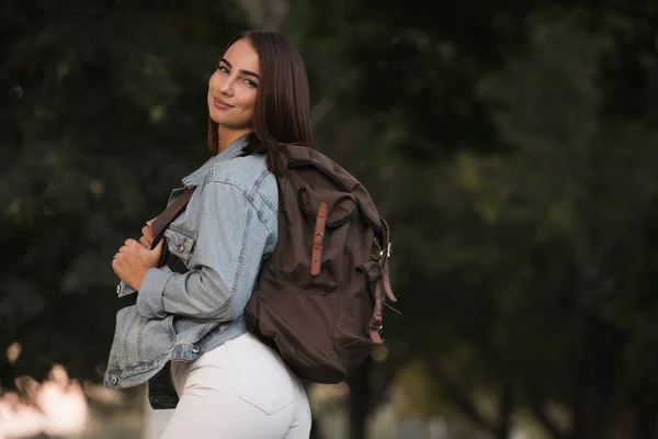 Vrouw in herfst seizoen kleren met rugzak in het park — Stockfoto