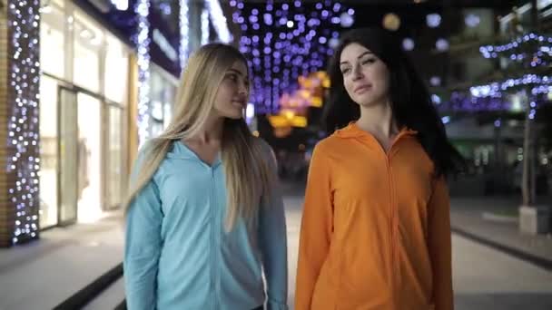 Przyjaciele młodych kobiet chodzenia i mówienia w nocy miasto ulica — Wideo stockowe