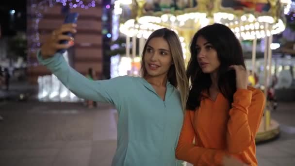 Dívky se selfie, ženy představují mobilní fotografie pomocí chytrého telefonu na nigth city — Stock video