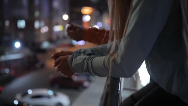 Közelkép a nők kezében támaszkodva a terasz, az éjszakai város — Stock videók