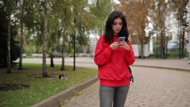 Mujer usando aplicación de teléfono inteligente caminando en la ciudad — Vídeo de stock