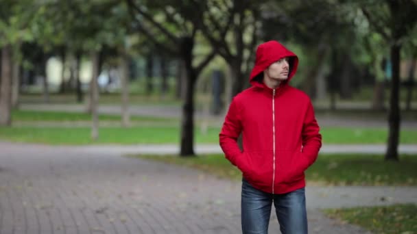 Hombre Joven Con Chaqueta Roja Caminando Parque Ciudad — Vídeos de Stock