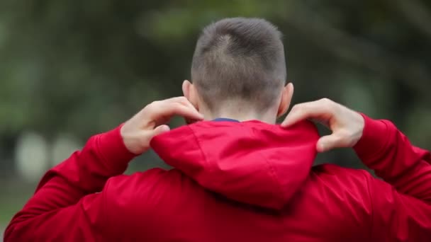 Mann Trägt Rote Kapuze Und Verschwindet Park — Stockvideo