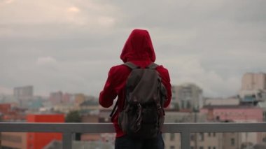 Adam turist alarak resim bulutlu cityscape duran bir çatı üzerinde