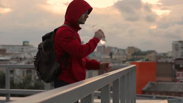 Müder Mann Trinkt Wasser Auf Terrasse Mit Blick Auf Stadtbild — Stockvideo