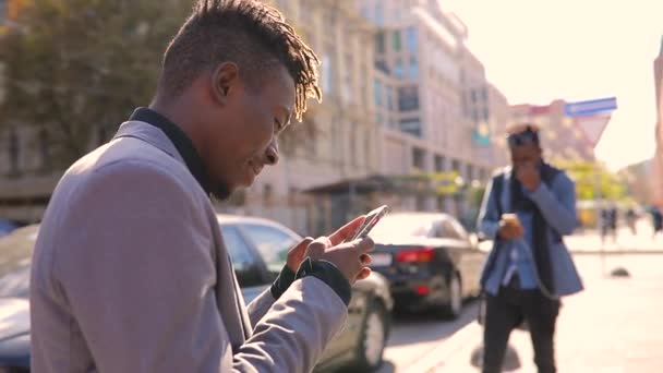 Африканские мужчины используют мобильное приложение в городских смсках или просмотре — стоковое видео
