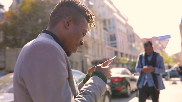 Hombres africanos amrica usando teléfono móvil en la ciudad mensajes de texto diálogo con interlocutor — Vídeos de Stock