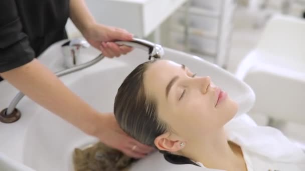 美容室ヘアサロンで頭を洗うと若い女性美容コンセプト — ストック動画