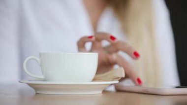 Telefonunuzun ve kafede oturan kahve Kupası ve smartphone portre