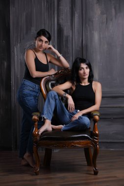 Stüdyo portre sandalye üzerinde iki kız kardeş