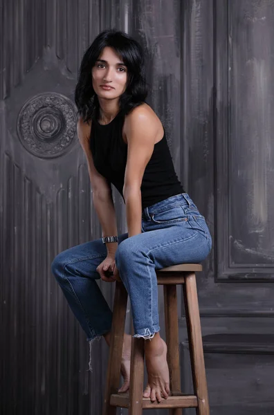 Woman sitting on a chair, studio portrait