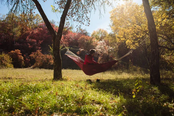 Человек Красном Отдыхает Сидя Гамаке Золотой Осенний День — стоковое фото