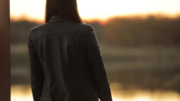 Calmo, cena tranquila, mulher irreconhecível olhando para o rio após o pôr do sol — Vídeo de Stock