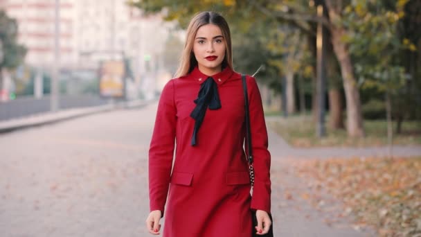 Sexy mujer atractiva en vestido rojo que va mirándome en el callejón de la ciudad — Vídeos de Stock