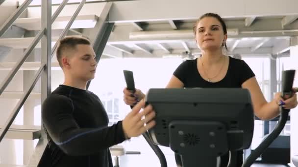 Unga fitness instruktör coaching nybörjare kvinna medan hon gör konditionsträning — Stockvideo