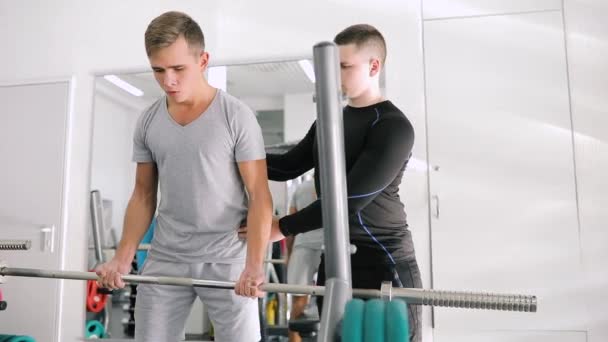 Entraîneur de fitness personnel corrige faire bicep exercice pour homme débutant — Video