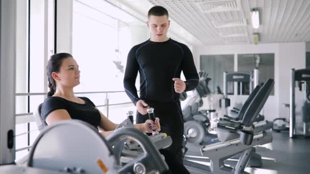 Persoonlijke fitness coach controle beginner sport vrouw in sportschool — Stockvideo