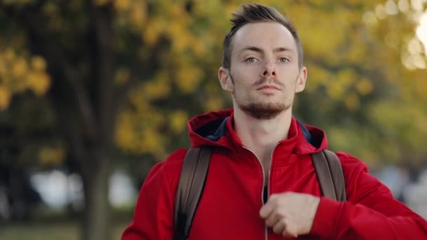 Hombre en rojo listo para la temporada de otoño frío, viste la capucha — Vídeo de stock
