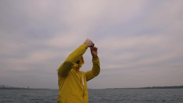Πεζοπορία ταξιδιώτη άνθρωπος σε κίτρινο σακάκι φωτογράφηση ουρανού από το smartphone — Αρχείο Βίντεο