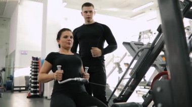 Kişisel fitness eğitmeni exercice acemi kadın için spor salonunda yapmak yardım