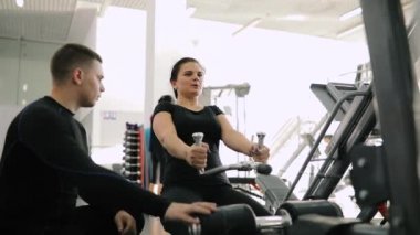 Kişisel fitness eğitmeni exercice acemi kadın için spor salonunda yapmak yardım