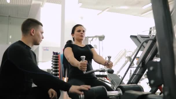 Persoonlijke fitnesstrainer helpen maken exercice voor beginner vrouw in sportschool — Stockvideo