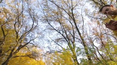 Sonbahar ormanın içinde smartphone ile yürüme sarı ceketli adamı