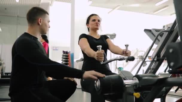 Osobisty trener fitness pomaga uczynić zawiadamianiu dla początkujących Kobieta w siłowni — Wideo stockowe