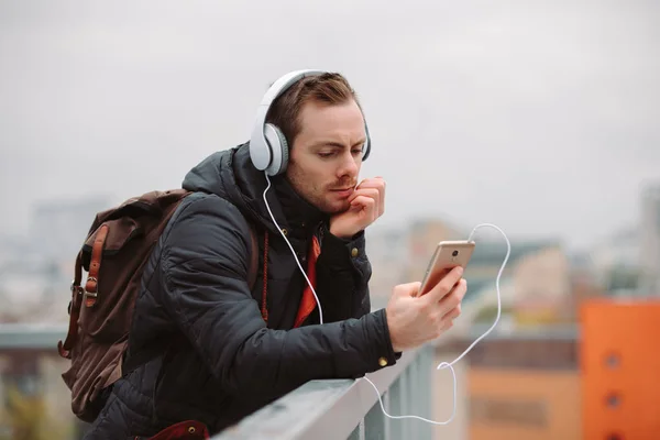 Man in headphones listening to music outdoors in city