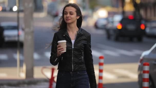 Hermosa mujer sosteniendo taza de café de papel y disfrutando de un paseo por la ciudad, cámara lenta — Vídeos de Stock