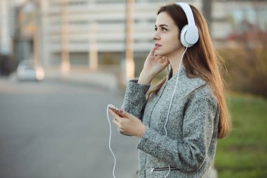 Kadın şehirde kulaklık ile müzik dinlemek