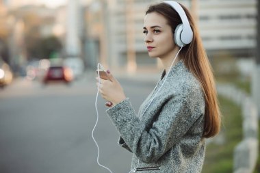 Kadın şehirde kulaklık ile müzik dinlemek
