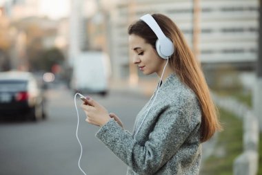 Kadın şehirde kulaklık ile müzik dinlemek