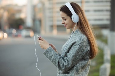 Kadın şehirde kulaklık ile müzik dinlemek