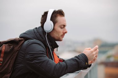 Adam açık havada şehirde müzik dinlerken kulaklık